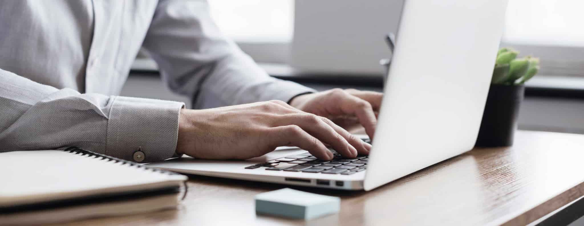 Man hands typing on computer keyboard closeup panoramic banner,